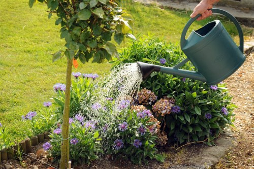 Operative wearing PPE while using hedge trimmer